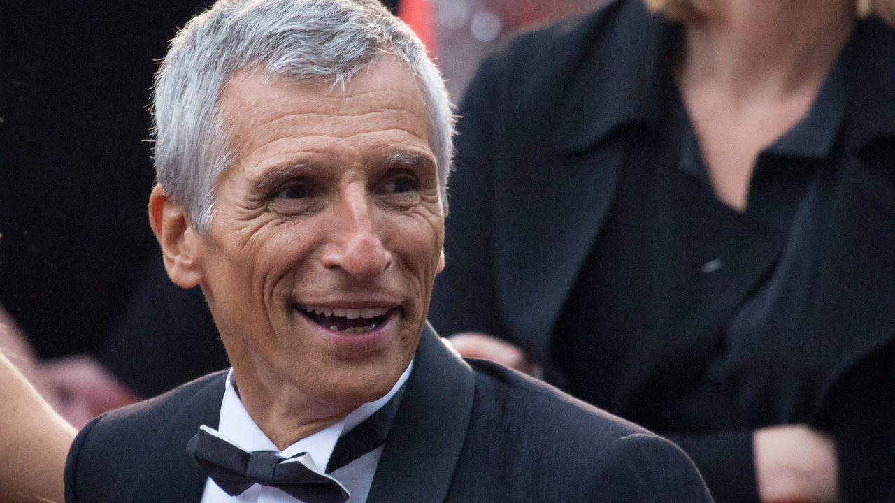 Photo : Nagui au festival de Cannes en 2019. Auteur : Joan Hernandez Mir. Licence : CC BY 2.0